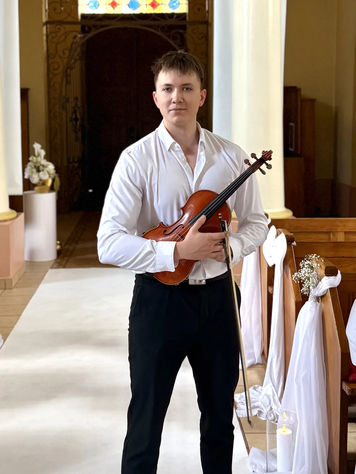 Michał Flakowski ze skrzypcami we wnętrzu kościoła